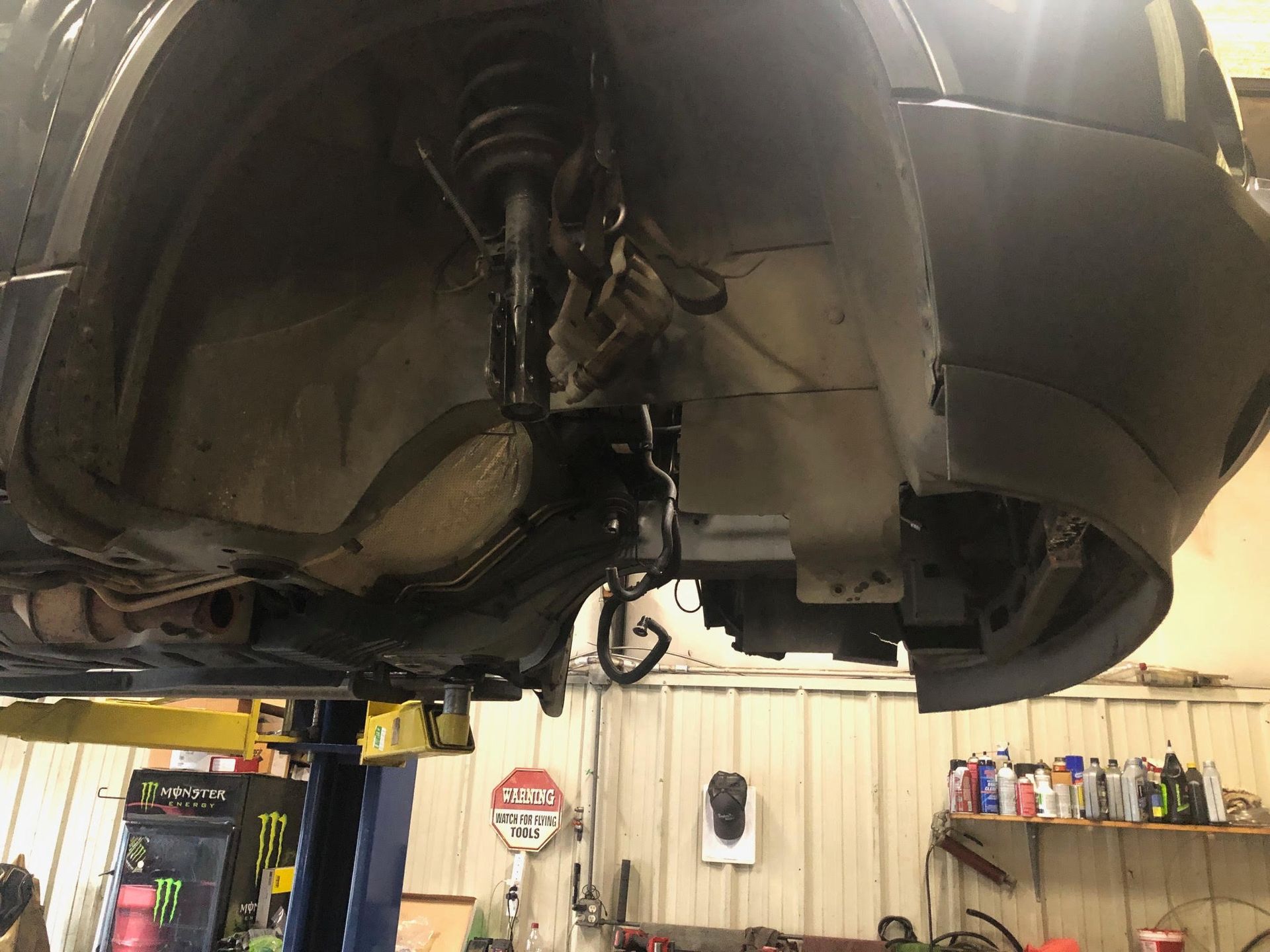 A car is sitting on a lift in a garage.