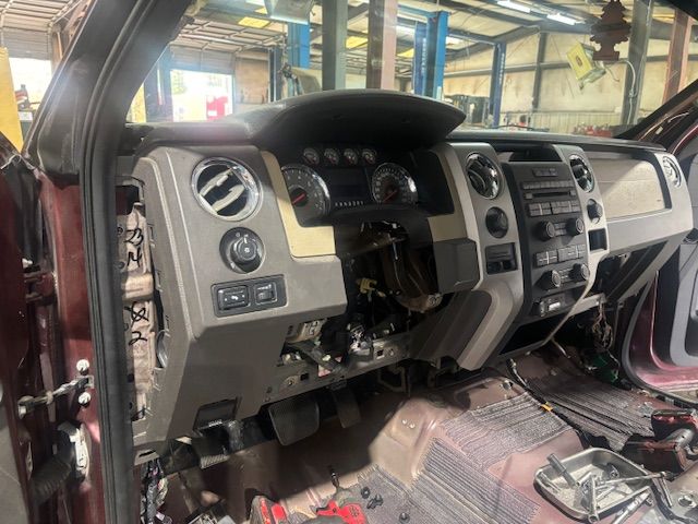 The dashboard of a truck is being removed in a garage.