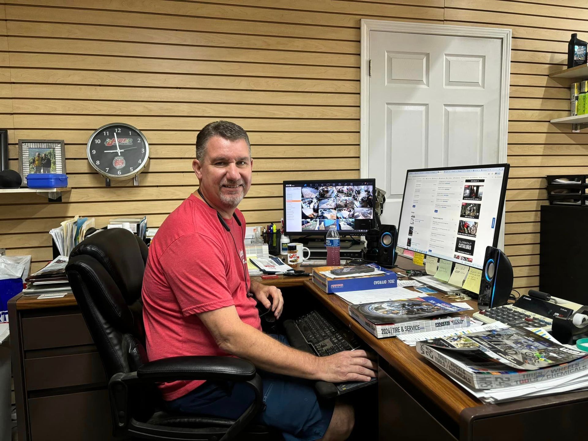 A man is sitting at a desk in front of a computer.