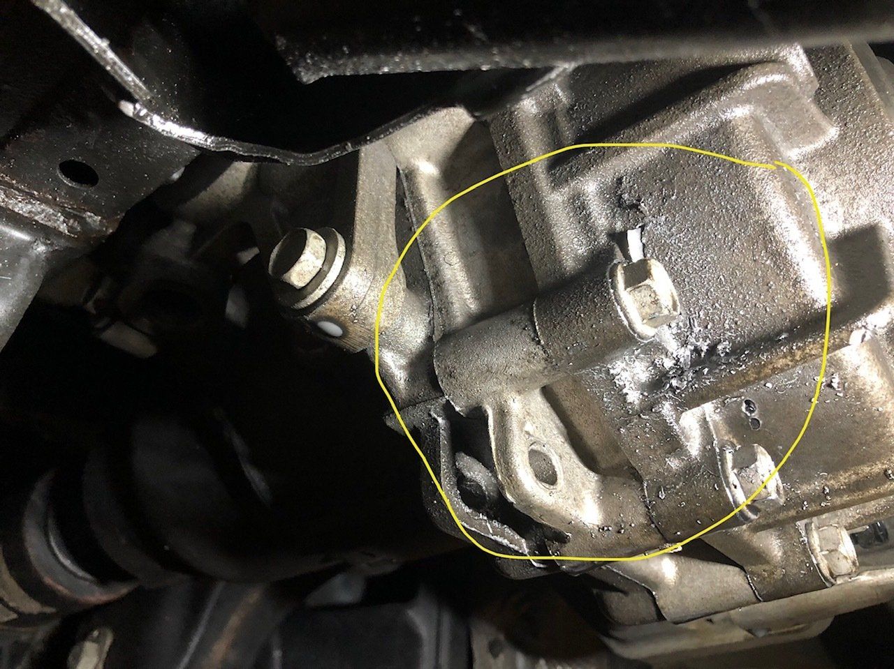 A close up of a car engine with a yellow circle around it.