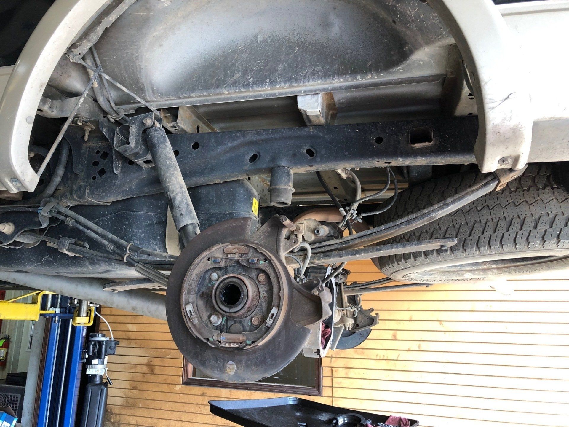A close up of the underside of a car in a garage.