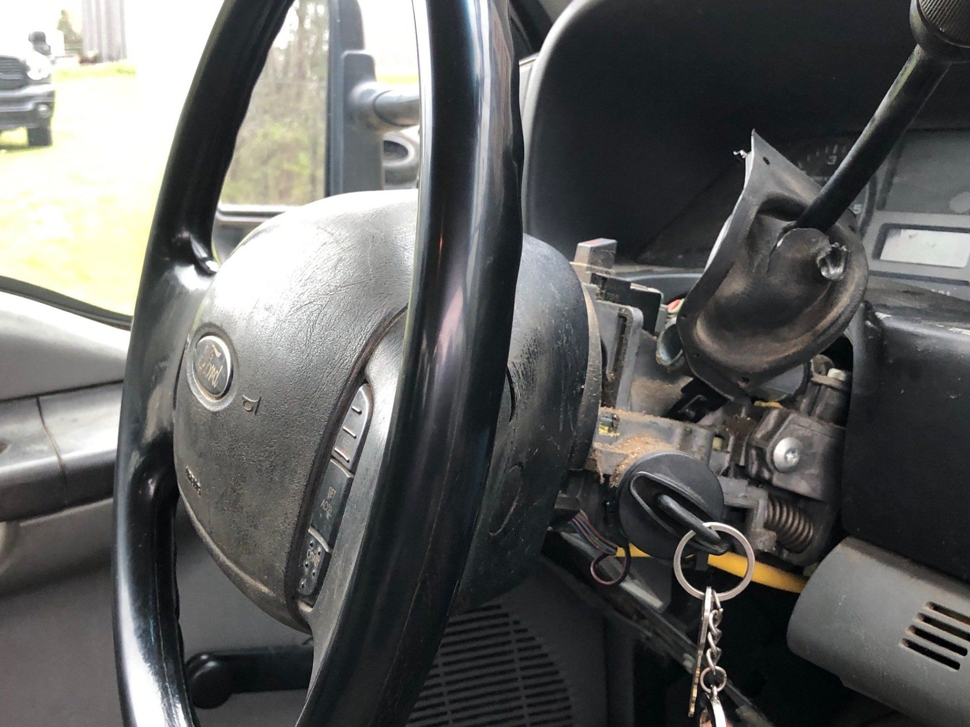 A car with a broken steering wheel and a broken key.