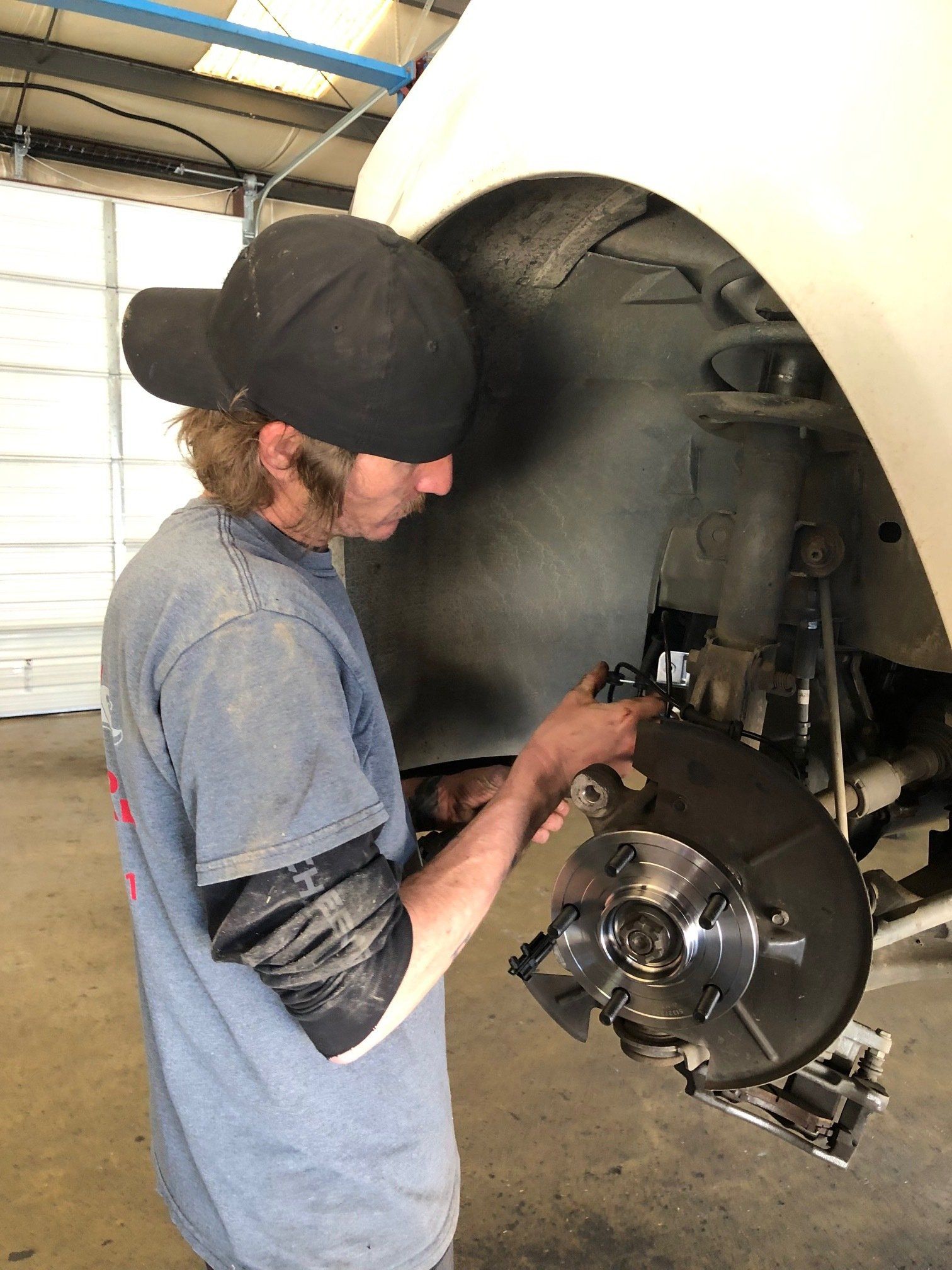 A man is working on a car in a garage.