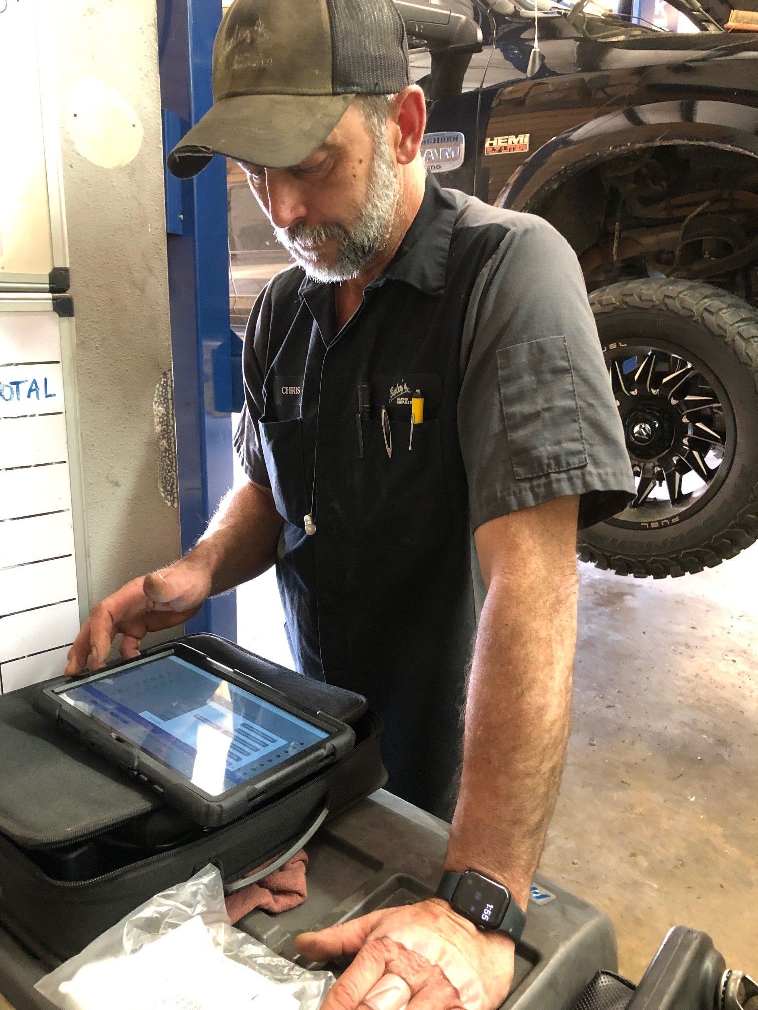 A man is using a tablet computer in a garage.