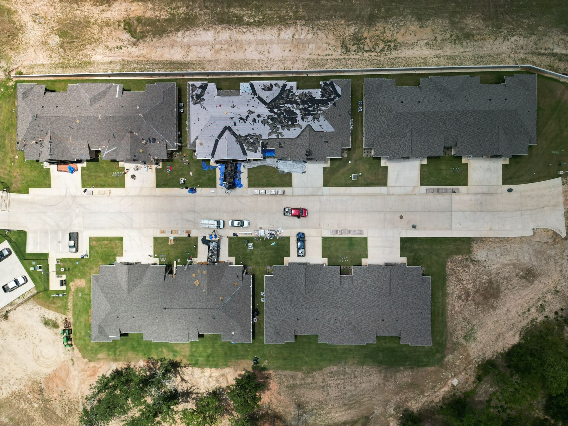Aerial view of a suburban apartment complex with six buildings, parking spaces, and grassy areas.
