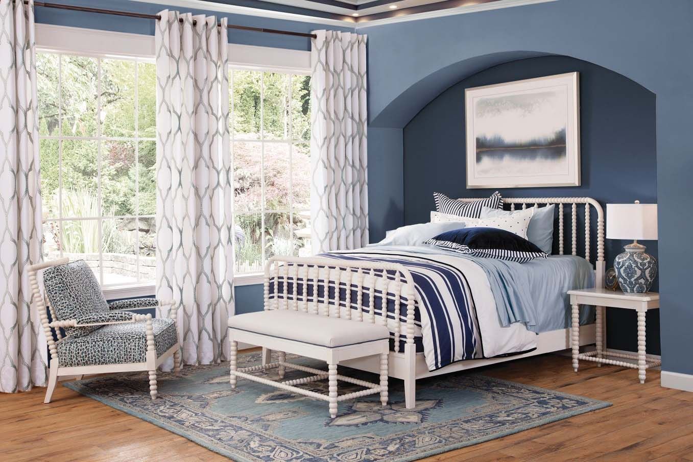 Blue-and-white bedroom with twin beds, arched alcove, large window, and striped curtains