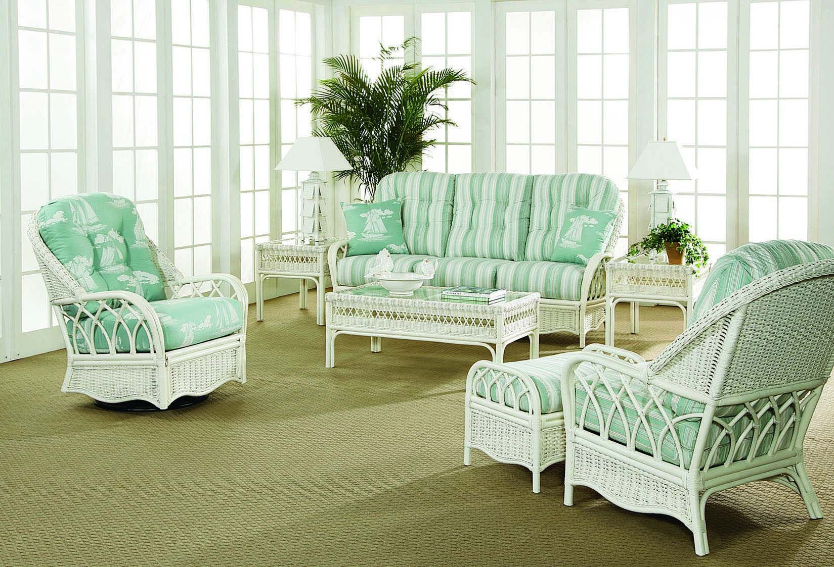 Mint-green wicker living room set with sofa, chairs, and table in a bright sunroom