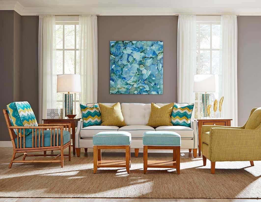 Bright living room with blue and gold furniture, white walls, and a blue abstract painting