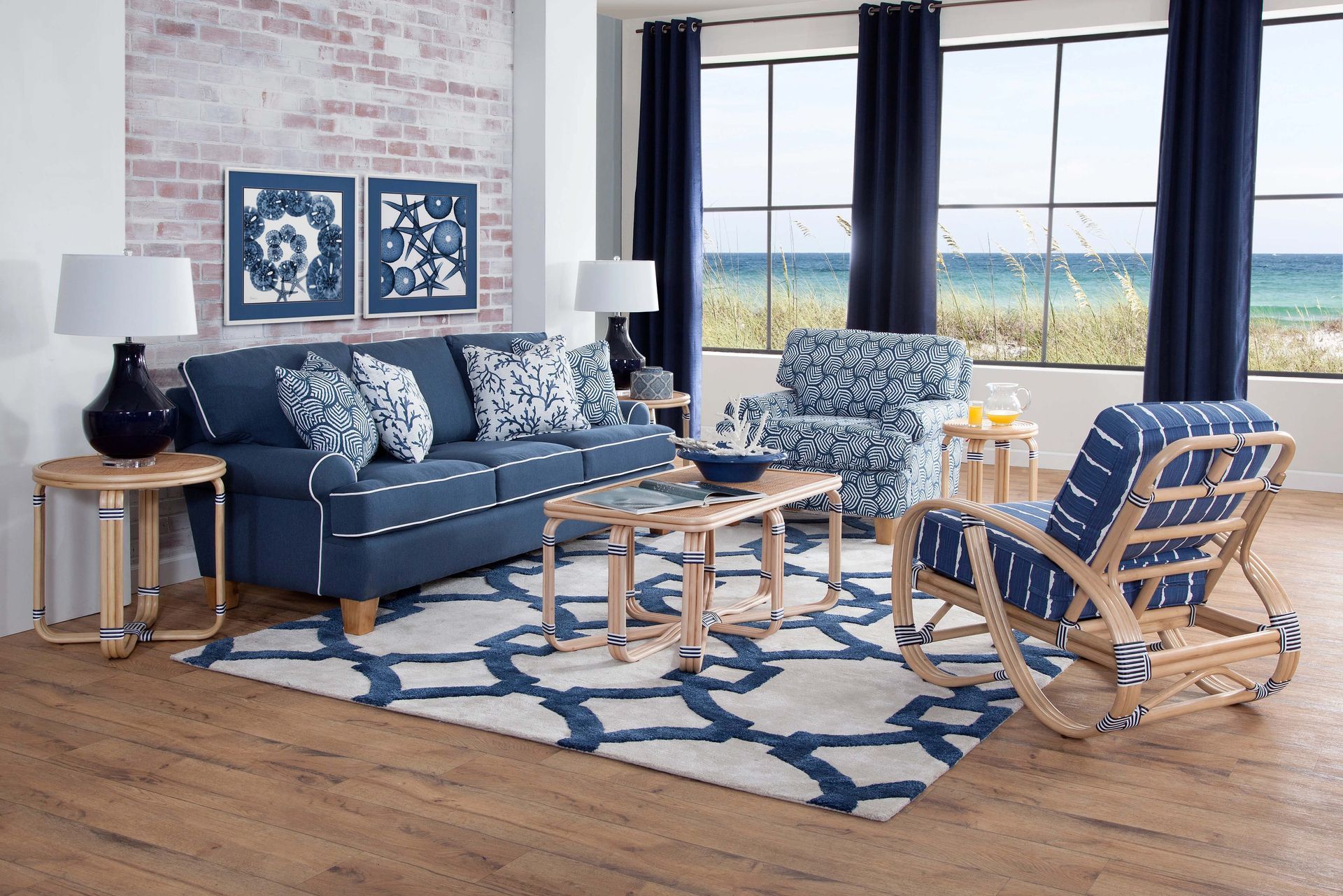 Blue-and-white coastal living room with sofa, rocking chairs, coffee table, and large windows overlooking water