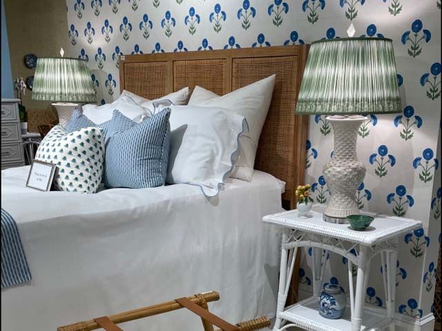 Cozy bedroom with white bedding, blue patterned wallpaper, and matching green lamps on bedside tables