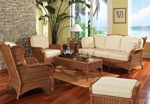 Cozy wicker living room with cream sofas, armchairs, ottoman, and ocean view through large windows