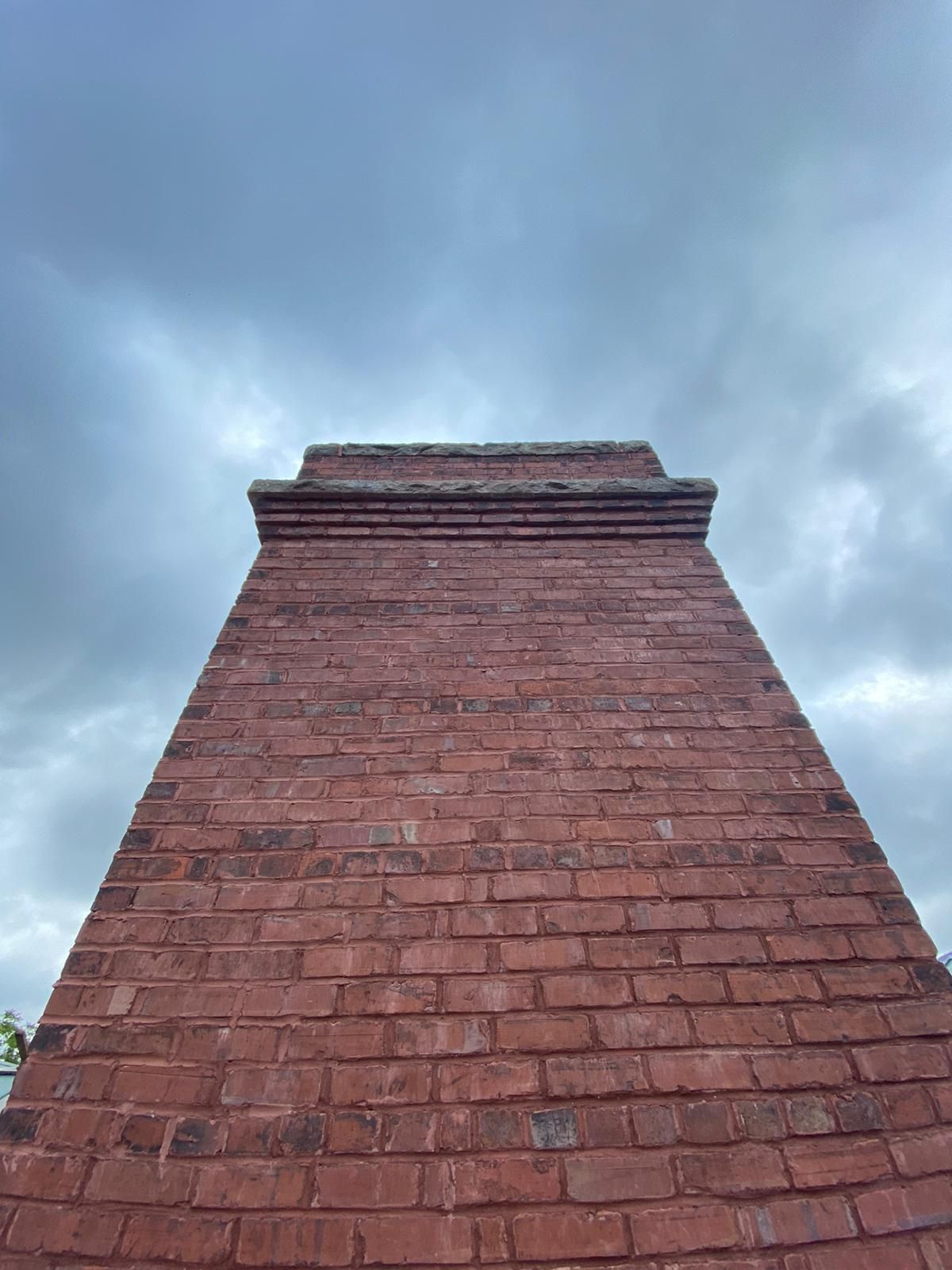 Red brick tower against a cloudy sky.