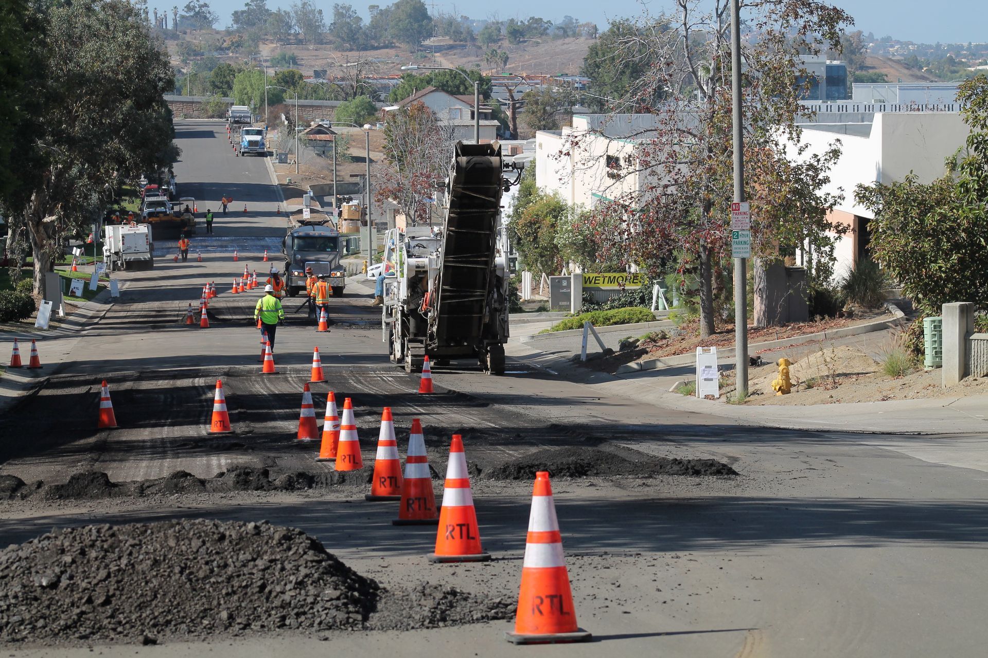 A row of orange and white traffic cones with the letters tl on them.