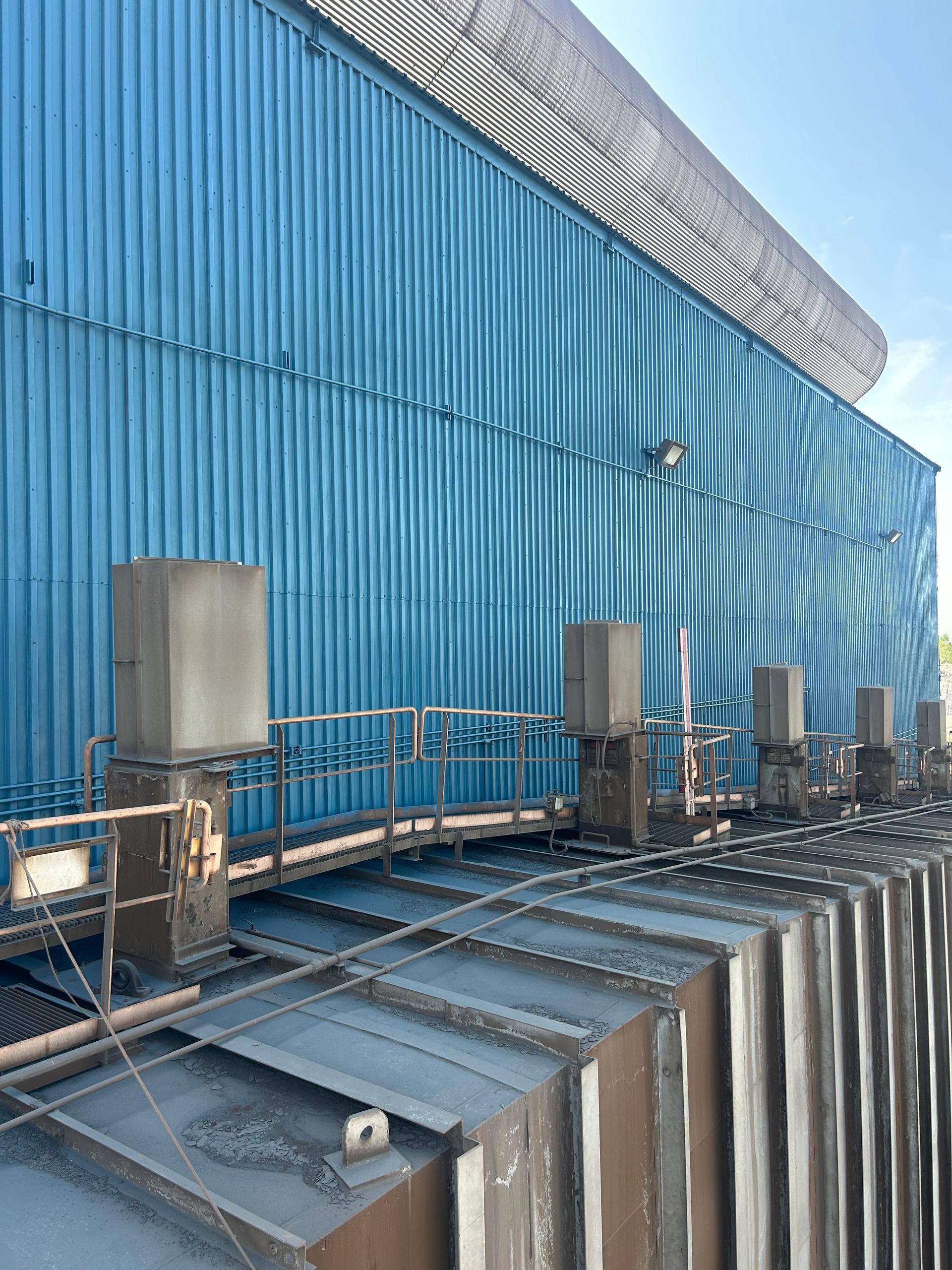 Blue industrial building with ventilation equipment on the roof.