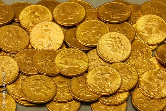 a bunch of gold coins are sitting on top of each other on a table