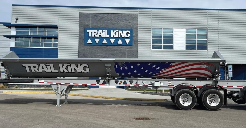A trail king trailer is parked in front of a building
