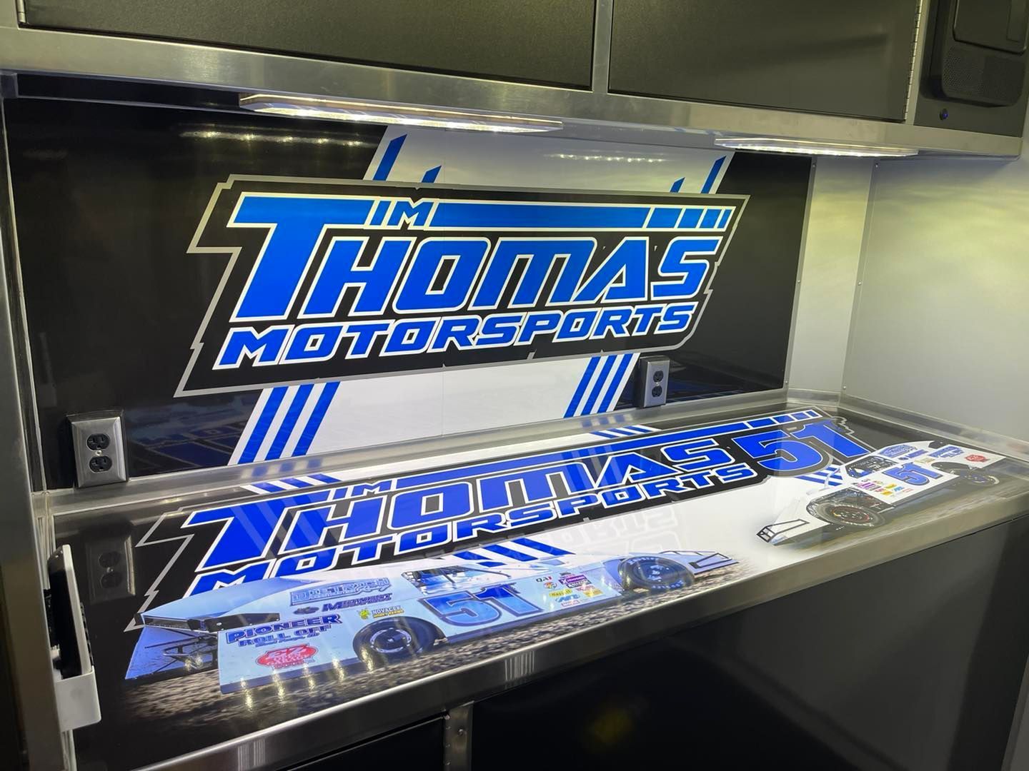 A table with a thomas motorsports logo on it
