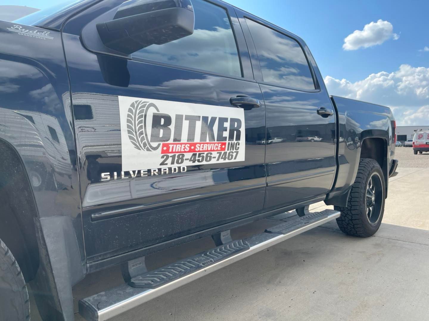 A black truck with a sticker on the side that says bitker tires and wheels.