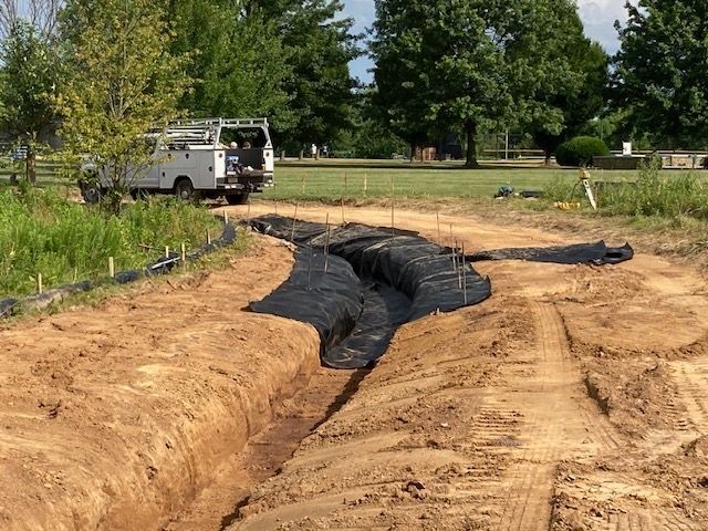 A white truck is parked on the side of a dirt road.