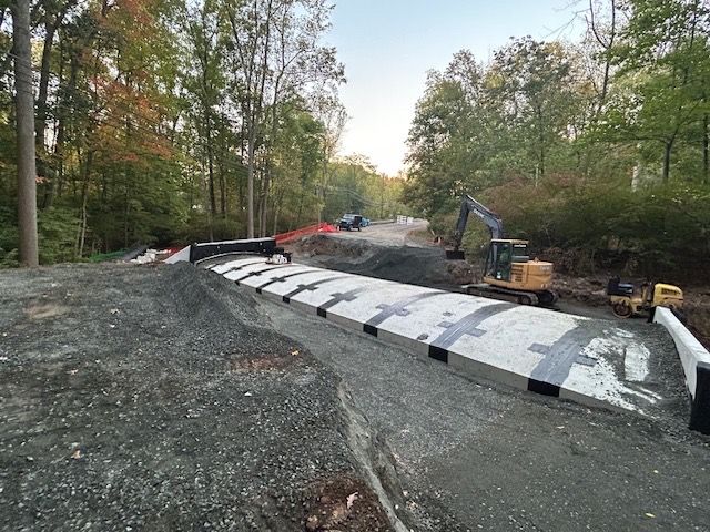 A construction site with a lot of dirt and trees in the background.