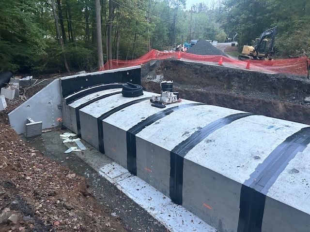 A large concrete structure is being built in the middle of a forest.