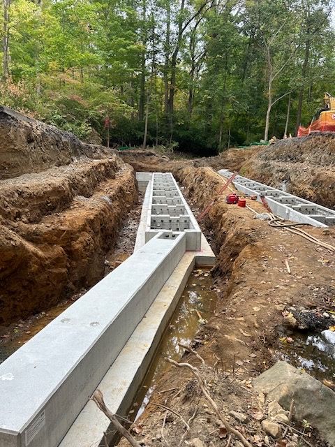 A construction site with a lot of dirt and trees in the background.