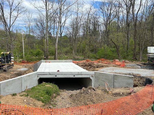A concrete bridge is being built in the middle of a forest.