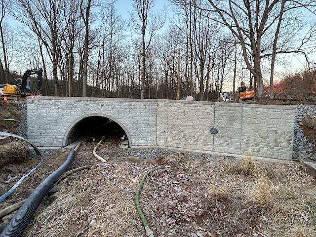 A concrete bridge is being built in the middle of a forest.