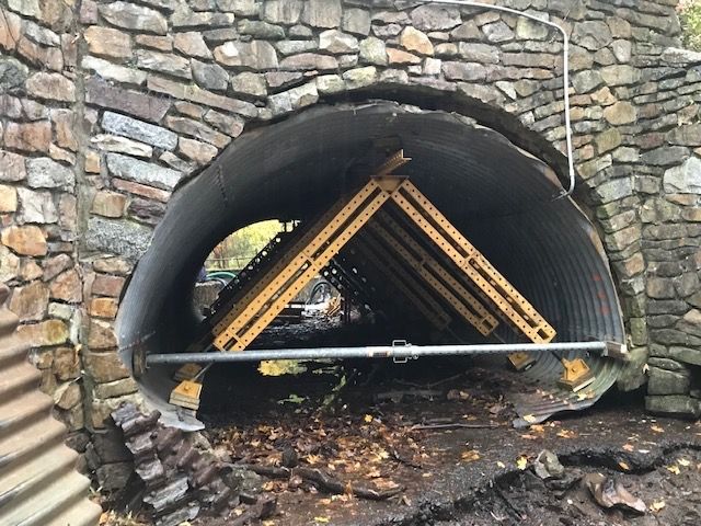 A stone tunnel with a wooden structure inside of it.