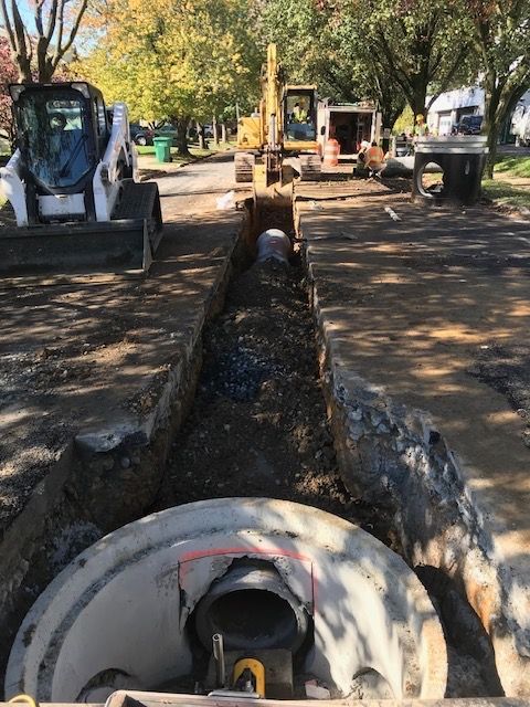 A manhole cover is being installed in a parking lot.