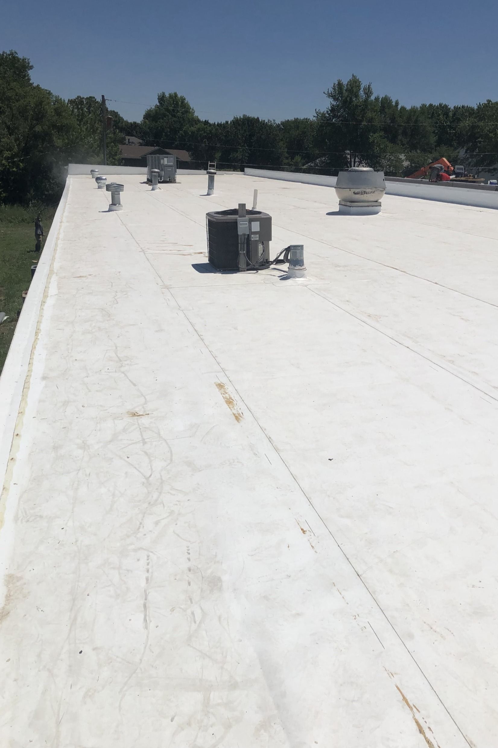 A white roof with a lot of chimneys on it.