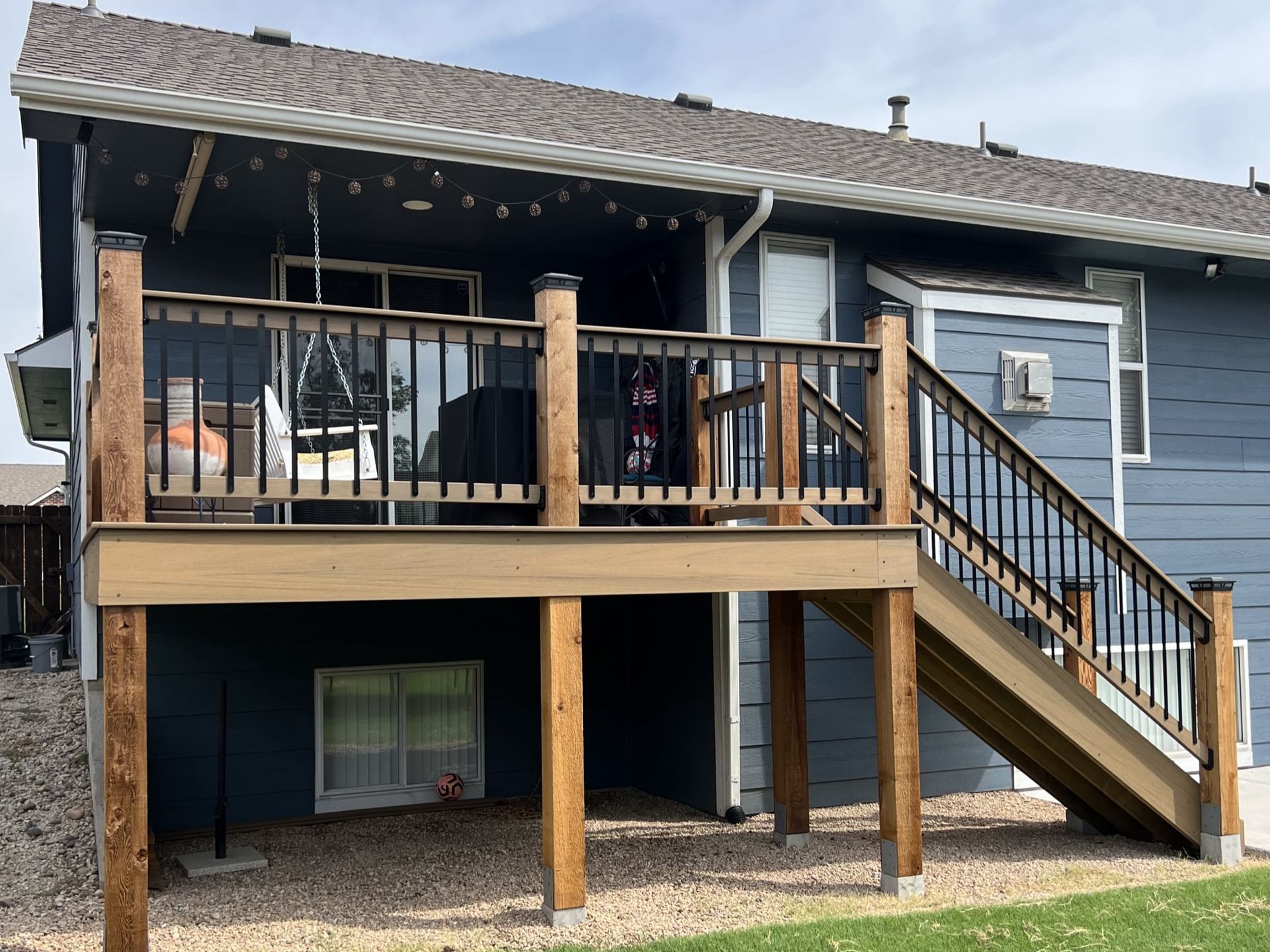 A blue house with a wooden deck and stairs