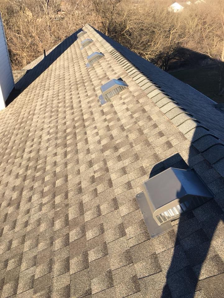 A roof with a lot of shingles and a chimney on it.