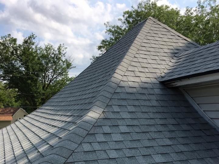 A roof with a pyramid shaped roof and trees in the background