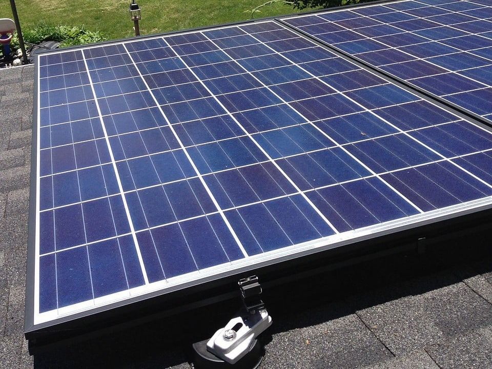 A row of solar panels are sitting on top of a roof