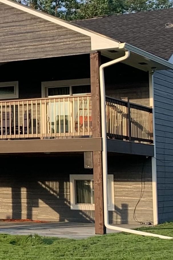 A house with a balcony and a gutter on the side of it.