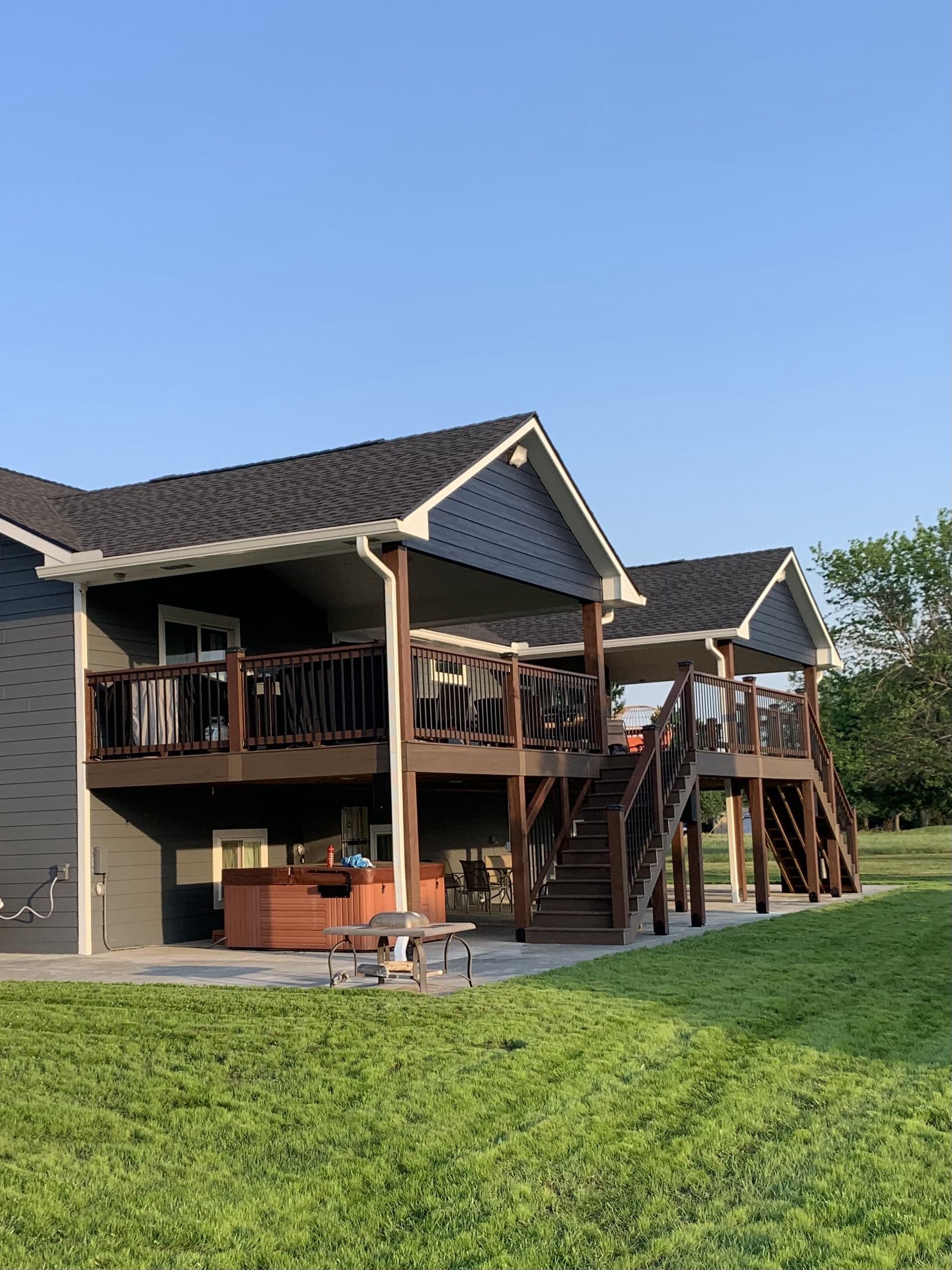 A large house with two decks and a hot tub in the backyard.