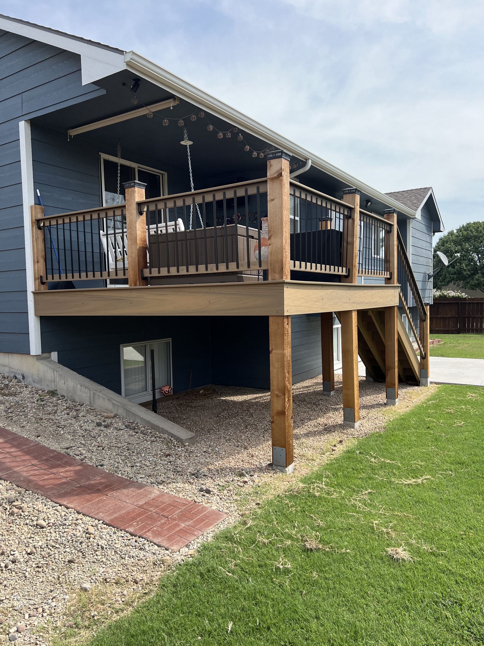 A blue house with a wooden deck and stairs.