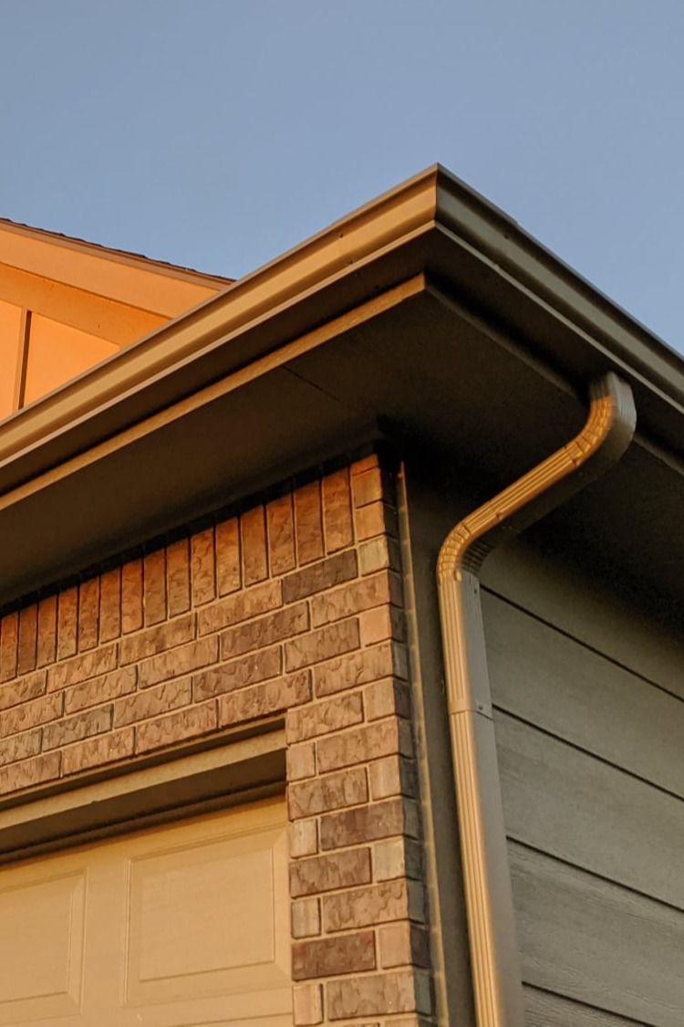 A close up of a gutter on the side of a house