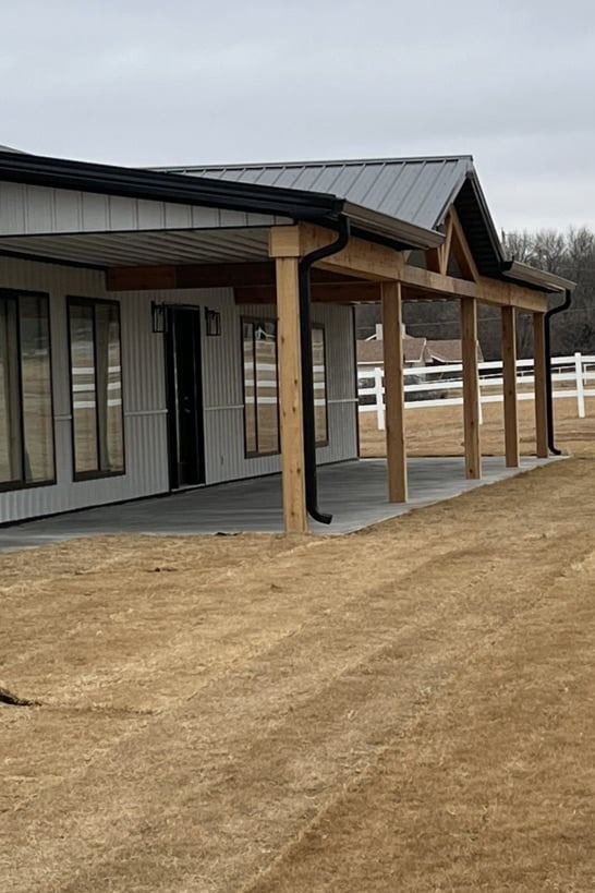 A house with a porch and a fence in the background.