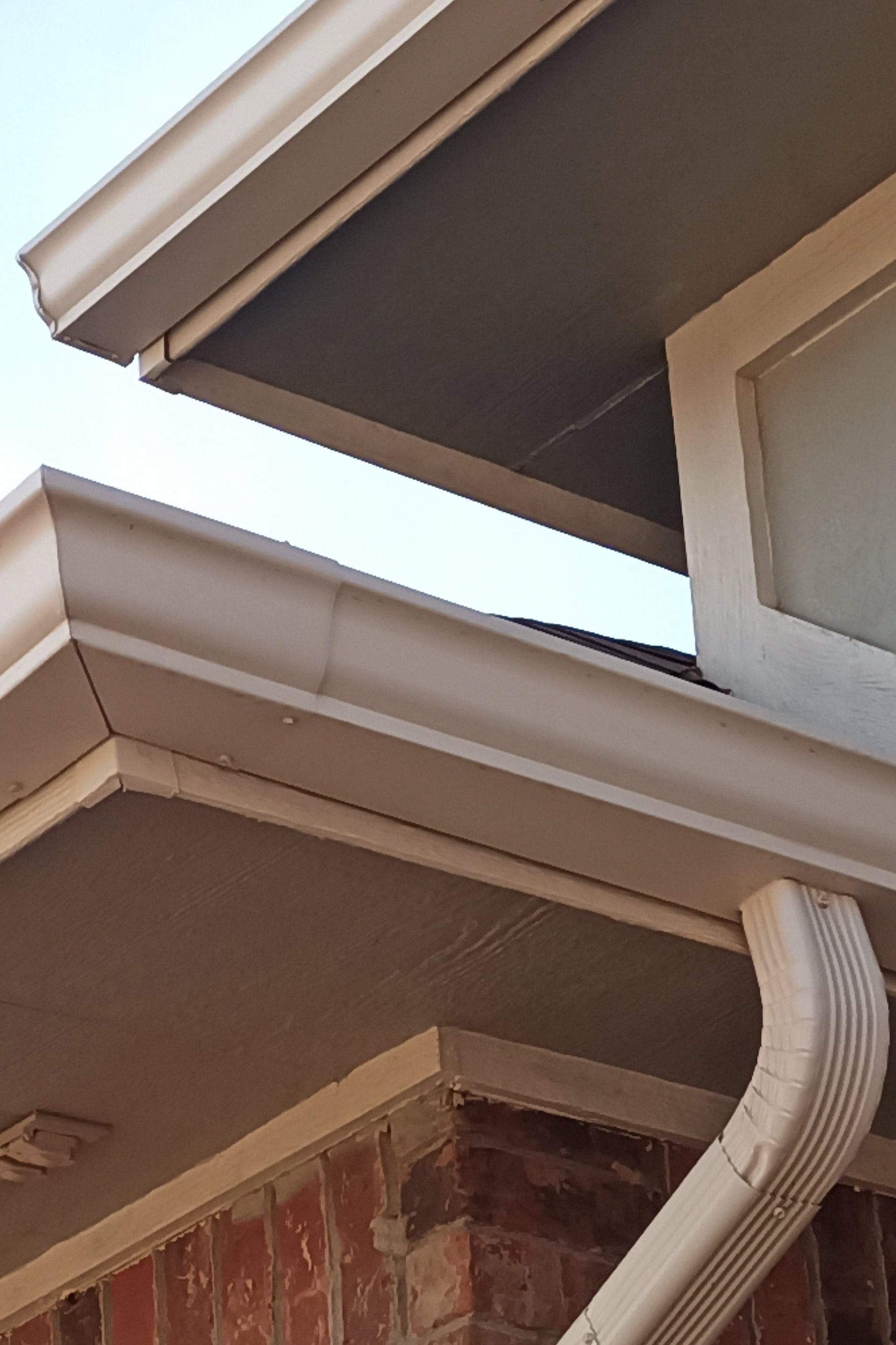 A close up of a gutter on the side of a house.