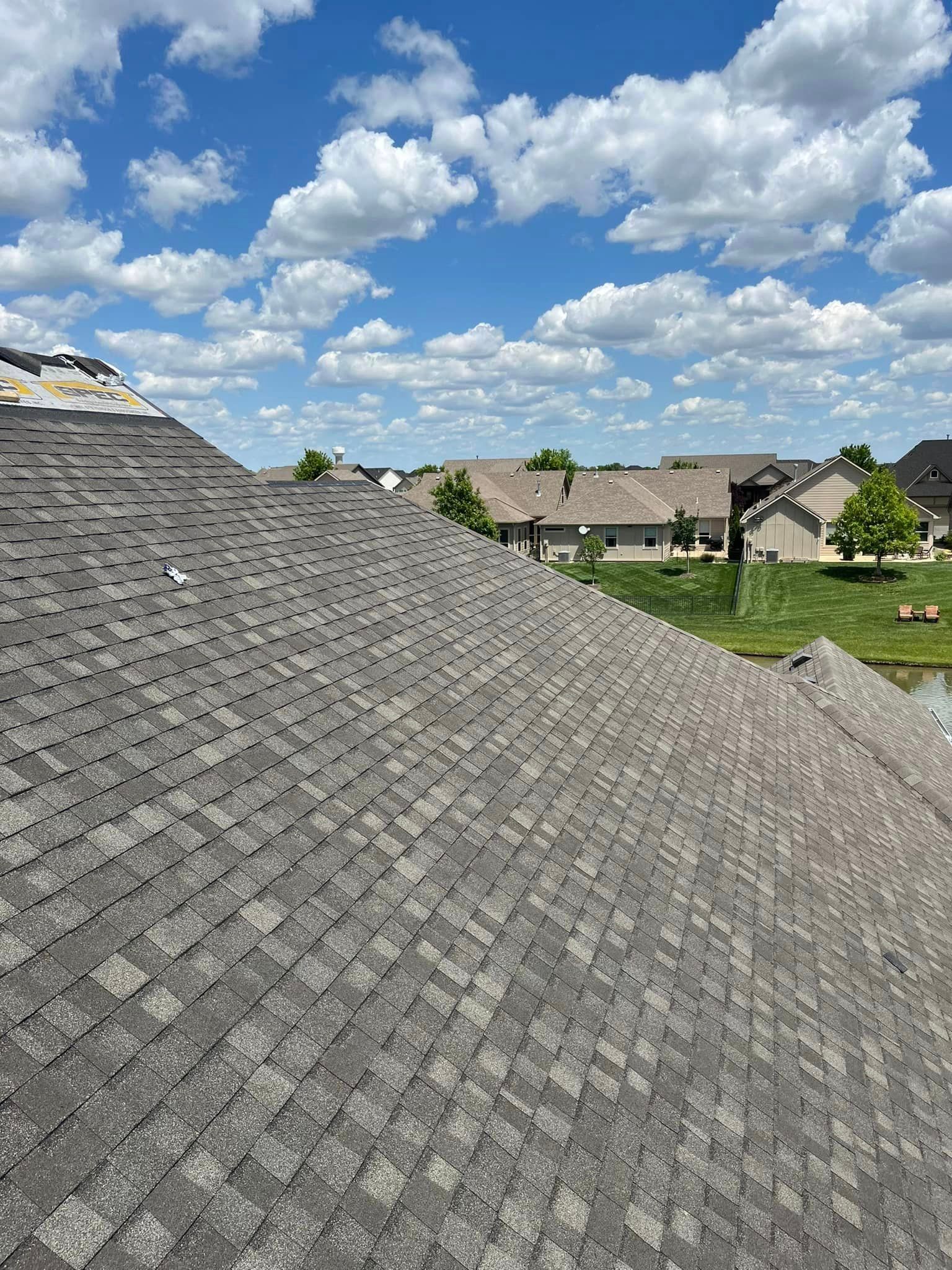 A roof of a house with a blue sky and clouds