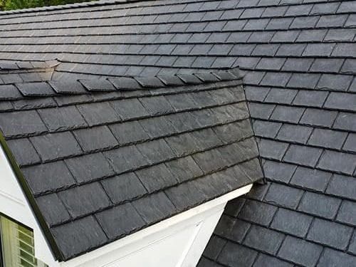 A close up of a slate roof on a house.