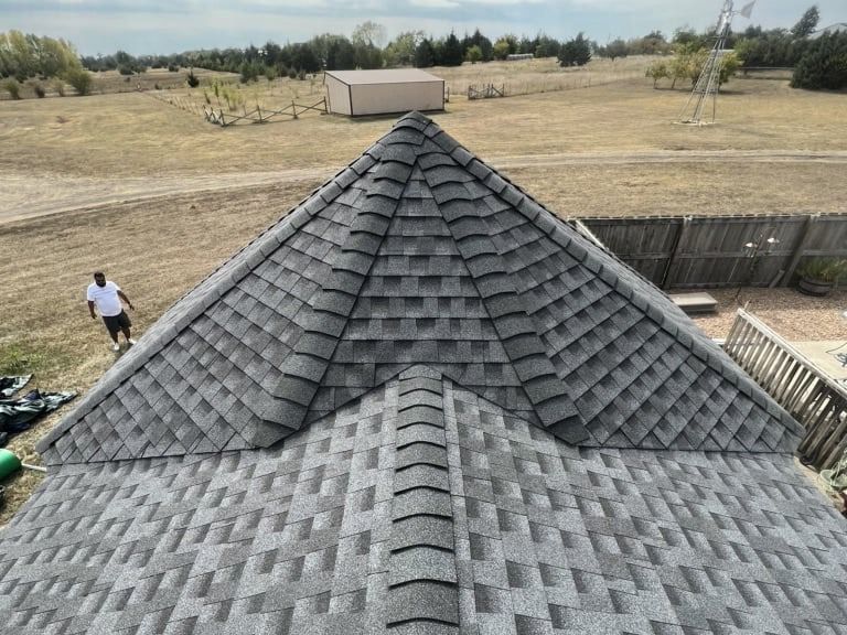 A man is standing on the roof of a house.