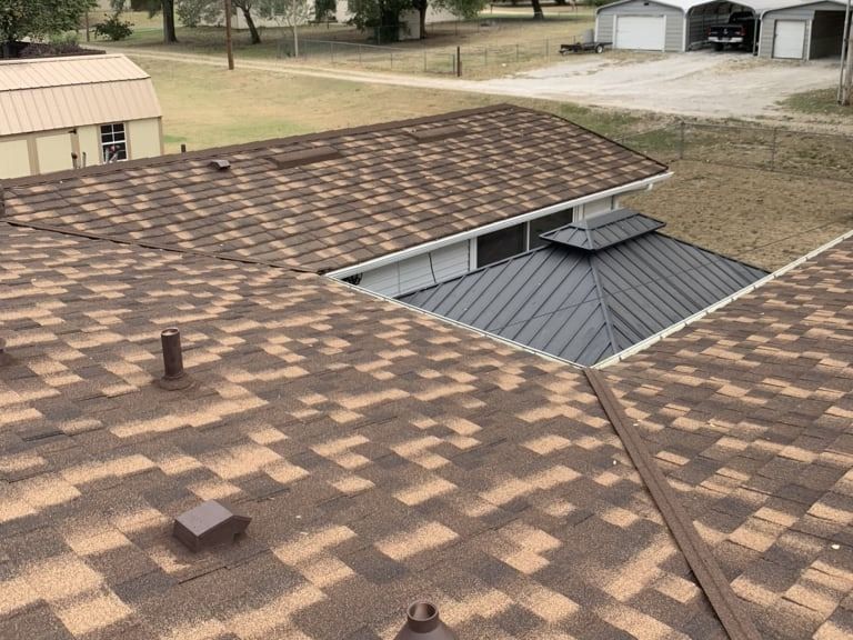 An aerial view of a house with a brown roof