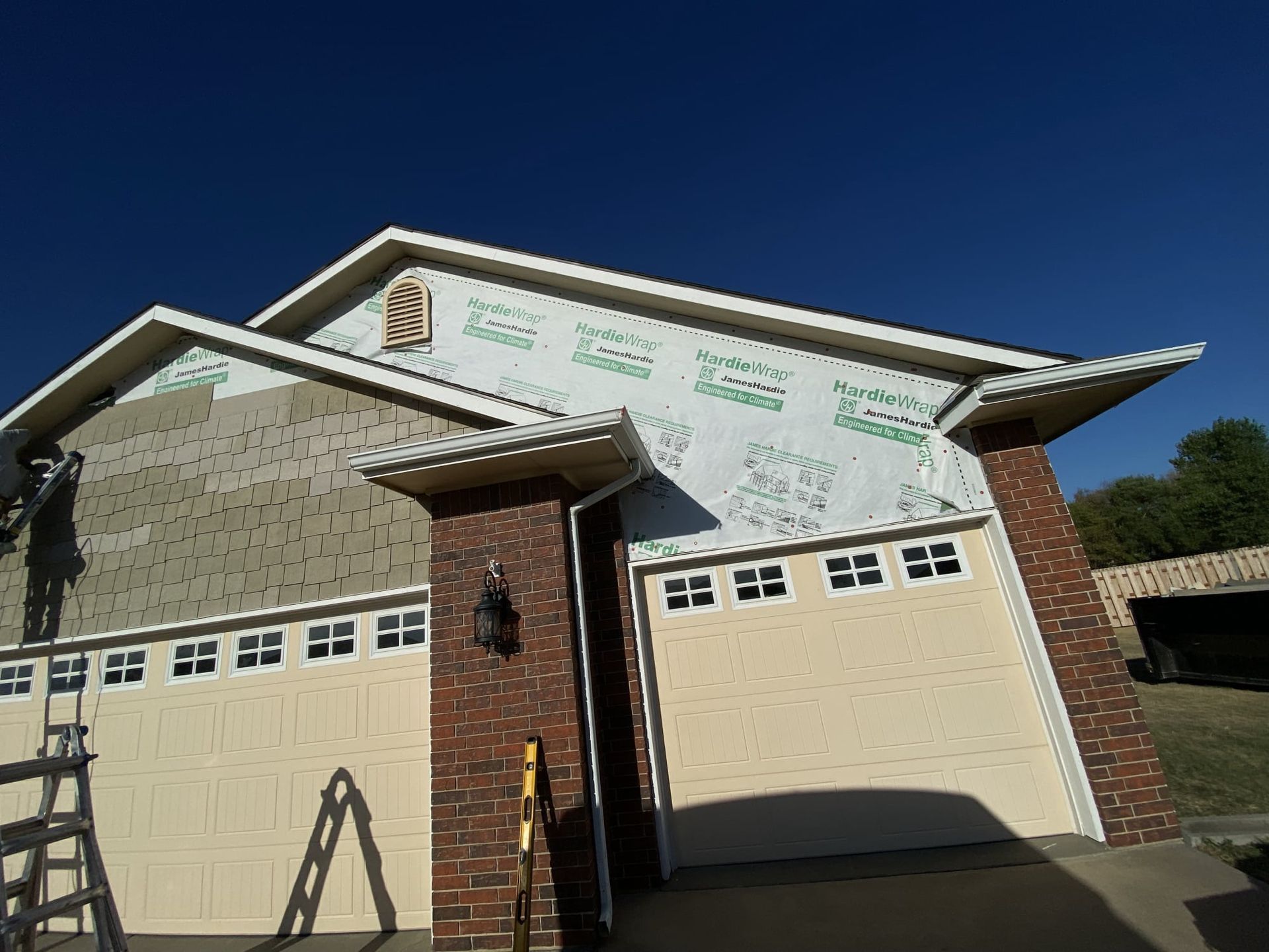 A house is being remodeled with a ladder in front of it.