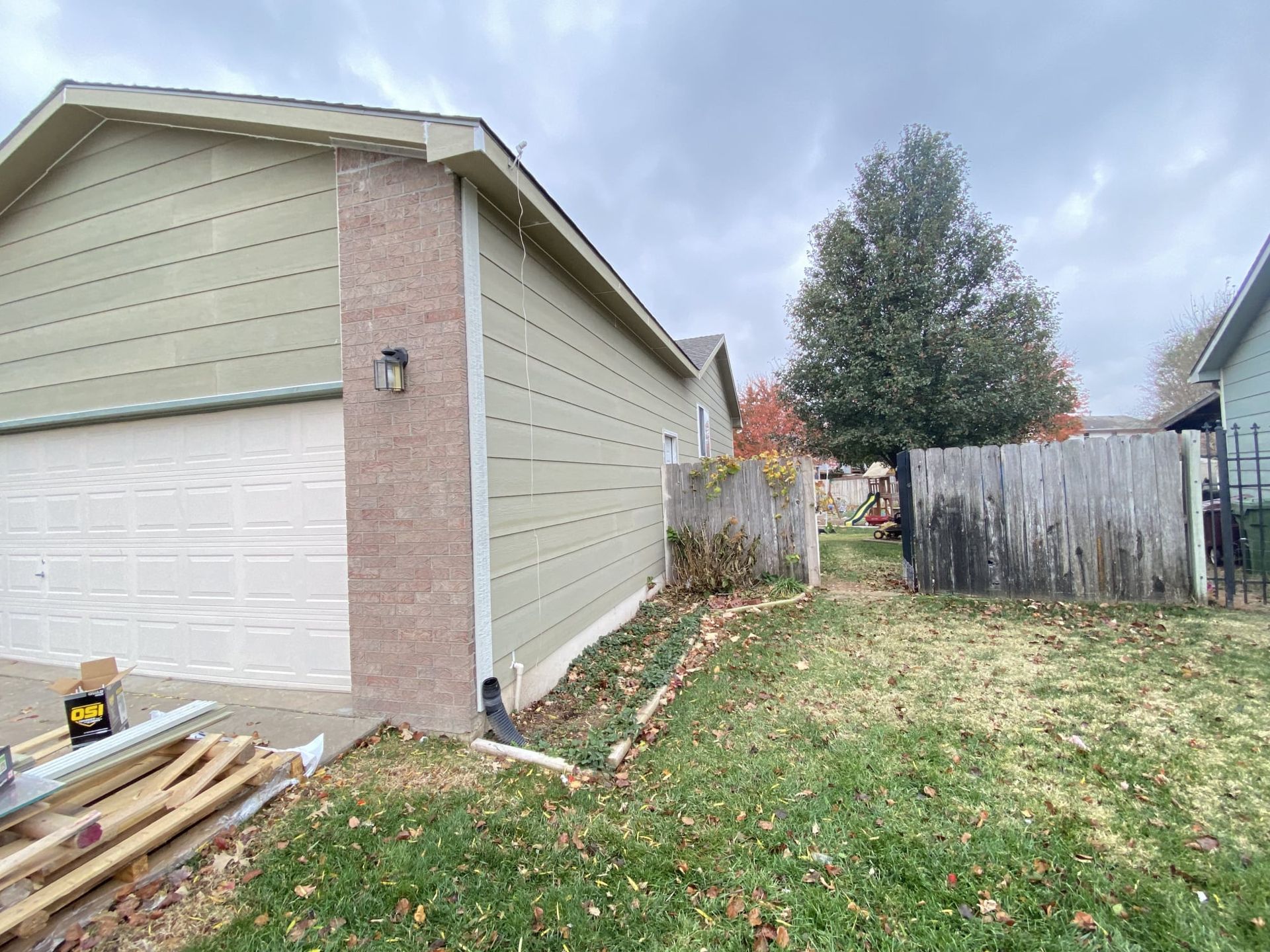 A house with a garage and a fence in the backyard.