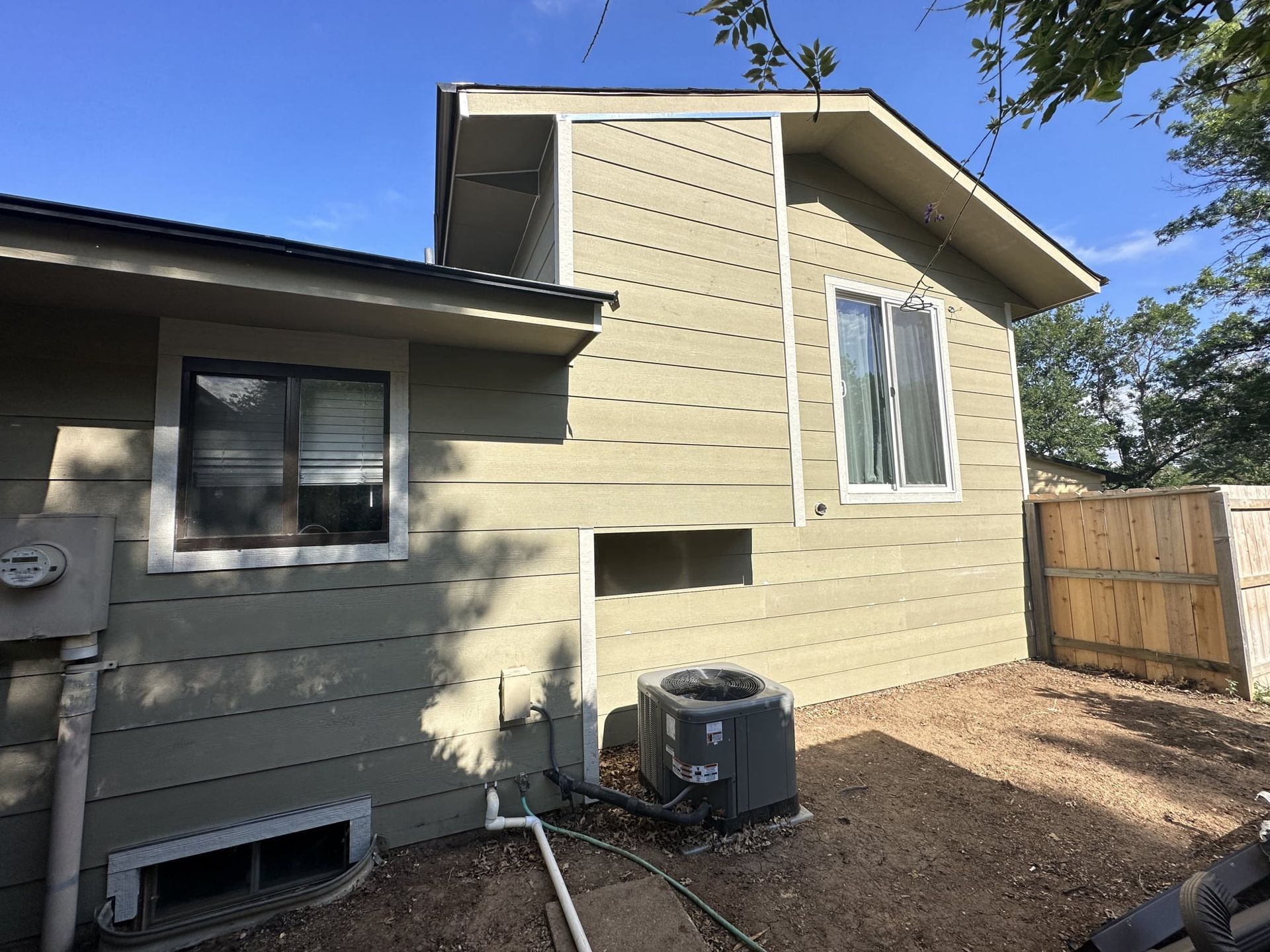 The back of a house with a window and air conditioner.
