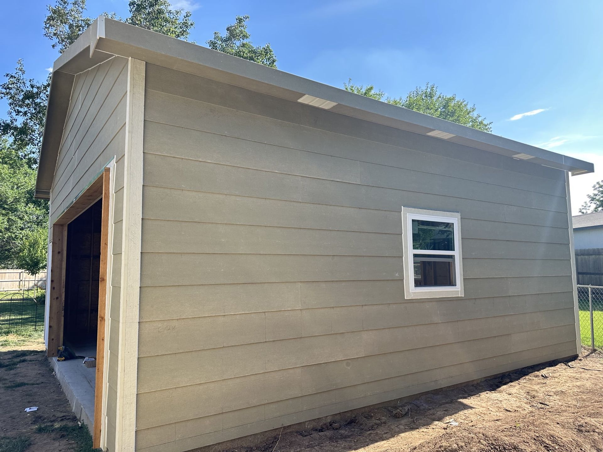 A small garage with a window on the side of it.