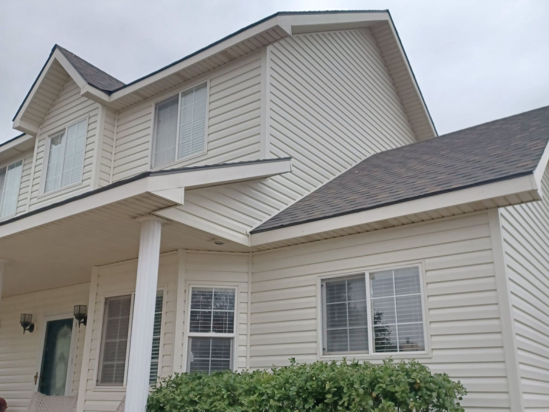 A white house with a gray roof and a lot of windows